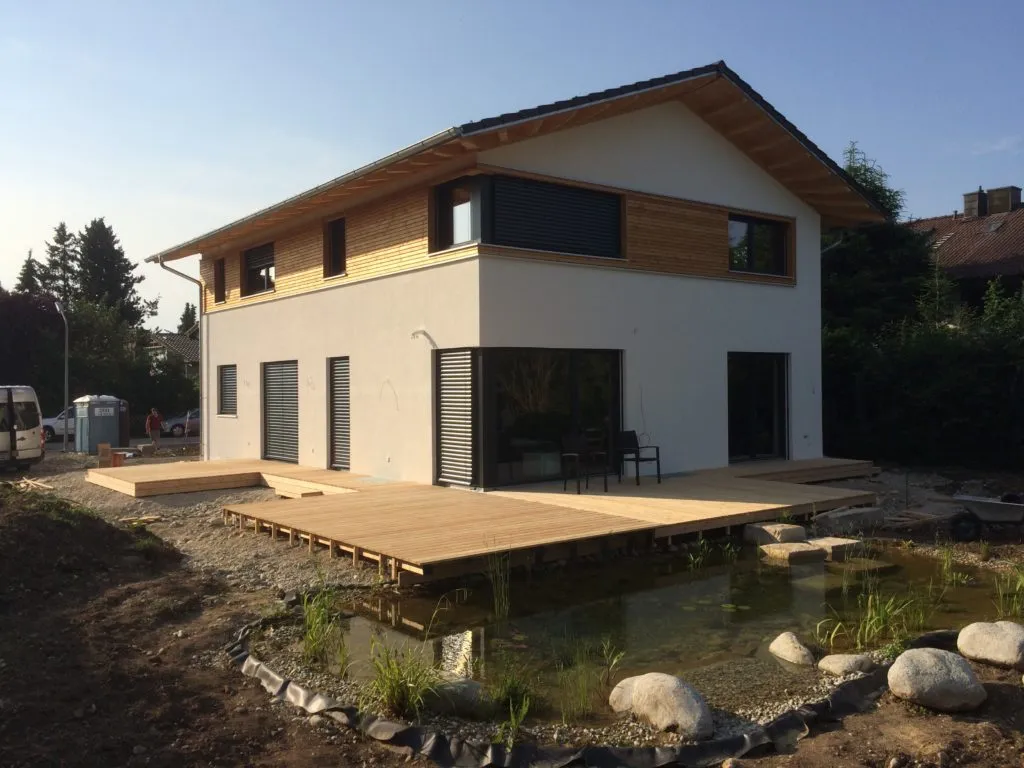 Einfamilienhaus mit hölzernem Giebel und großer Holzterrasse