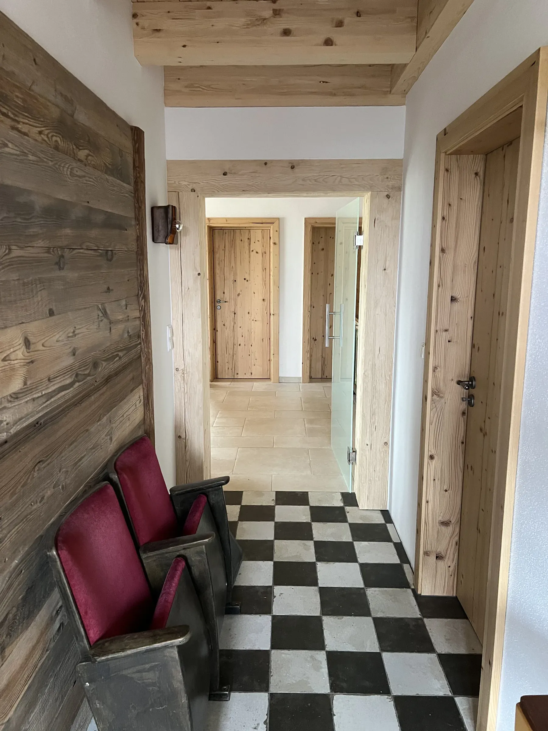Flur mit Altholz-Wandverkleidung, Innentüren und Zargen aus astigem Massivholz sowie einer Ganzglastür